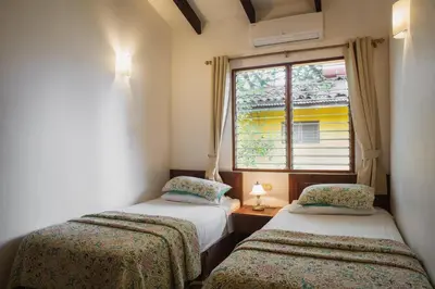 two beds in a room with a window at Villas Macondo in Tamarindo