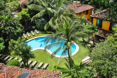 an aerial view of a resort with a swimming pool and palm trees at Villas Macondo in Tamarindo
