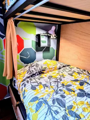 a bedroom with a bunk bed with a colorful comforter at Mangifera Hostel in Grecia