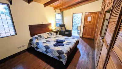 a bedroom with a bed with a blue teddy bear on it at Mangifera Hostel in Grecia