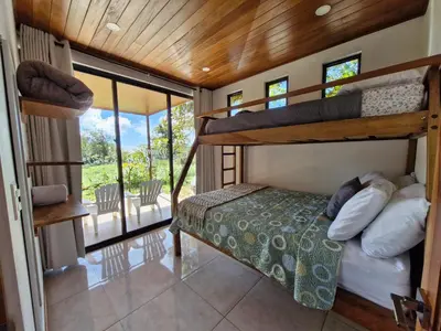 a bedroom with bunk beds and a balcony at Puma Meraki Mountain View Monteverde in Monteverde Costa Rica