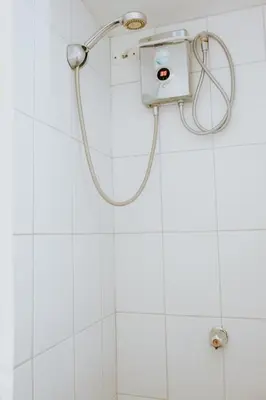 a shower in a white tiled bathroom at Wanderlust in Jacó