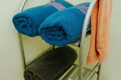 a rack with blue towels and a mirror at Wanderlust in Jacó