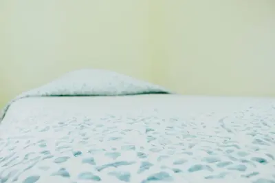a white bed with a pillow on top of it at Wanderlust in Jacó
