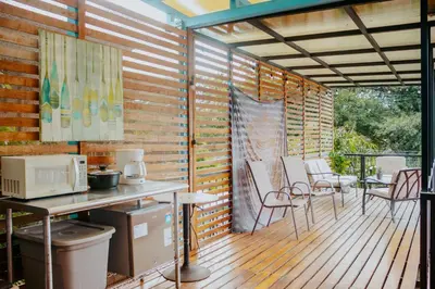 a patio with a table and chairs on a deck at Wanderlust in Jacó