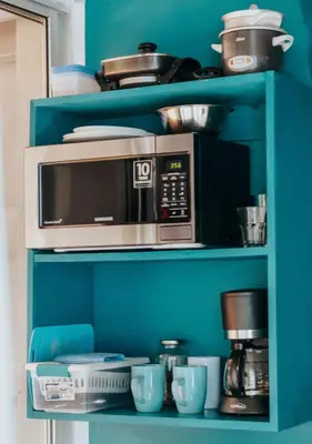 a microwave sitting on top of a blue shelf at Wanderlust in Jacó