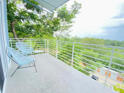 a blue chair on the balcony of a house at Altamar in Santa Teresa Beach