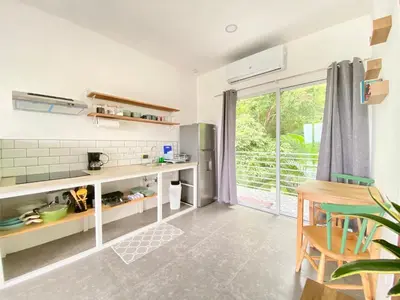 a kitchen with a counter and a table and a window at Altamar in Santa Teresa Beach