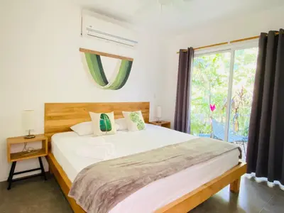 a bedroom with a large bed and a window at Altamar in Santa Teresa Beach