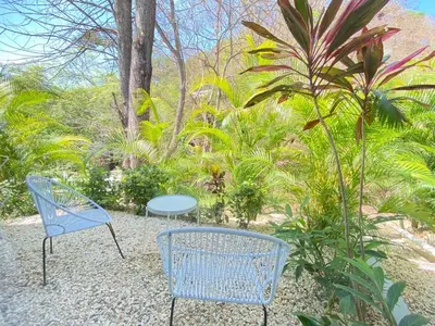 two blue chairs and a table in a garden at Altamar in Santa Teresa Beach