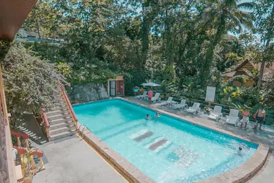 an overhead view of a swimming pool with people in it at Hotel Tres Banderas in Manuel Antonio