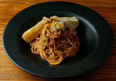 a plate of spaghetti and bread on a table at Hotel Tres Banderas in Manuel Antonio