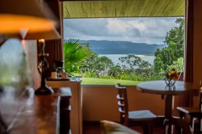 a view from a restaurant with a table and a large window at Hotel Nepenthe B&B in El Castillo de La Fortuna