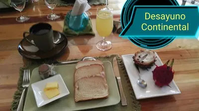 a table with a plate with bread and cheese and a drink at Hotel Rio Celeste Finca L´ Etoile Celeste in El Achiote