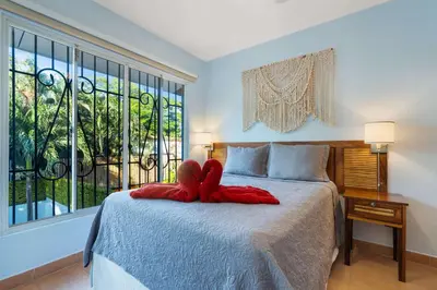 a bedroom with a bed with a red bow on it at Spacious Home with Private Pool & Covered Patio Near the Beach in Playa Flamingo