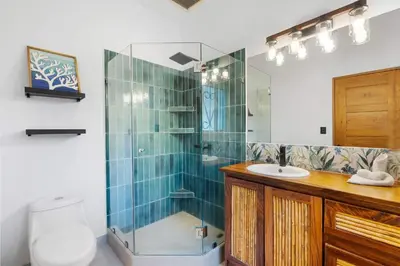 a bathroom with a shower and a toilet and a sink at Spacious Home with Private Pool & Covered Patio Near the Beach in Playa Flamingo