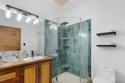 a bathroom with a sink and a glass shower at Spacious Home with Private Pool & Covered Patio Near the Beach in Playa Flamingo