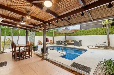 an outdoor patio with a swimming pool and a pergola at Spacious Home with Private Pool & Covered Patio Near the Beach in Playa Flamingo