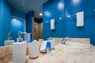 a bathroom with a sink and a blue wall at Nicely Decorated Ground-Floor Unit in Front of Pool at Pacifico in Coco in Coco