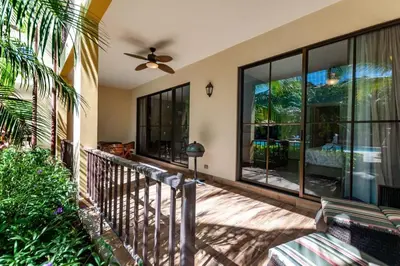 a balcony of a house with a ceiling fan at Nicely Decorated Ground-Floor Unit in Front of Pool at Pacifico in Coco in Coco