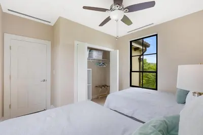 a bedroom with two beds and a ceiling fan at Renovated Condo in High-End Resort Community with Spectacular Mountain Views, Modern Design, and Beach Club Access in Coco