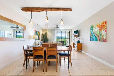 a dining room and living room with a table and chairs at Renovated Condo in High-End Resort Community with Spectacular Mountain Views, Modern Design, and Beach Club Access in Coco