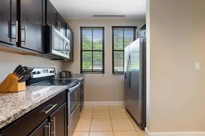 a kitchen with a stainless steel refrigerator at Renovated Condo in High-End Resort Community with Spectacular Mountain Views, Modern Design, and Beach Club Access in Coco