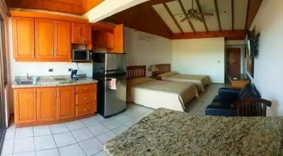 a kitchen with two beds and a kitchen with a counter at Flamingo Marina Resort Studio in Playa Flamingo