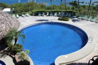a large blue swimming pool with chairs around it at Flamingo Marina Resort Studio in Playa Flamingo