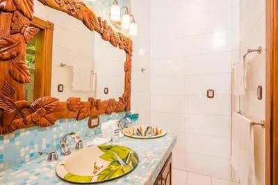 a bathroom with a sink and a mirror at Blue Jewel Oceanfront Private Villa in Tamarindo
