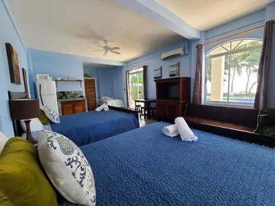 a bedroom with two beds with blue walls and a window at Hermosa Beach House in Playa Hermosa