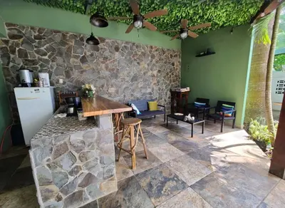 a kitchen with a stone wall and a table and chairs at Hermosa Beach House in Playa Hermosa