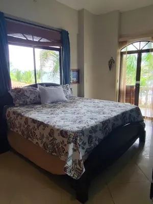 a large bed in a bedroom with a window at Hermosa Beach House in Playa Hermosa