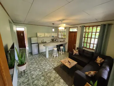 a living room with a couch and a kitchen at Hermosa Beach House in Playa Hermosa