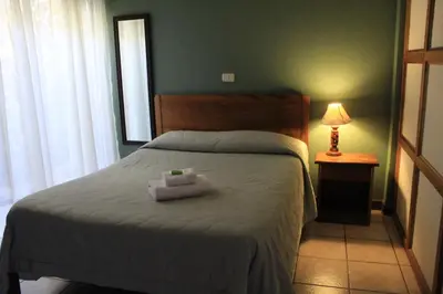 a bedroom with a bed with two towels on it at Hotel Guadalupe in Tilarán