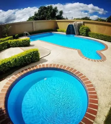 a large blue swimming pool in a yard at Hotel Guadalupe in Tilarán