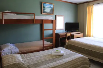 a hotel room with two bunk beds and a desk at Hotel Guadalupe in Tilarán