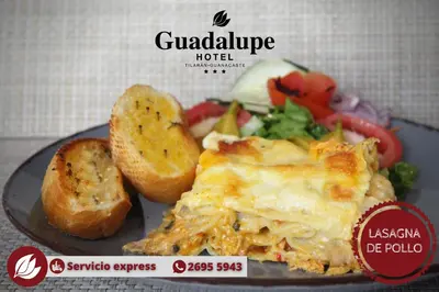 a plate of food with a sandwich and a salad at Hotel Guadalupe in Tilarán