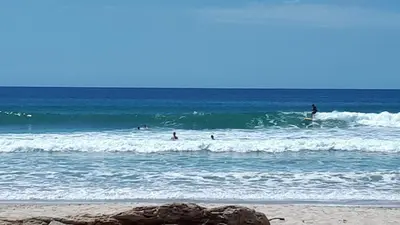 a group of people riding the waves in the ocean at Casa SILURI UP in Santa Teresa Beach