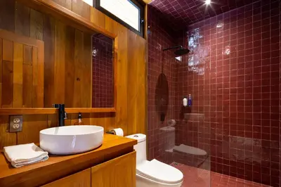 a bathroom with a sink and a toilet and a shower at Somos in Santa Teresa Beach
