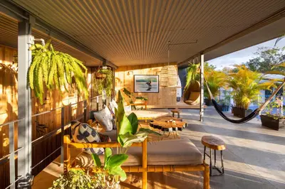 a patio with plants and tables and chairs at Somos in Santa Teresa Beach