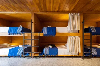 four bunk beds in a room with wooden ceilings at Somos in Santa Teresa Beach
