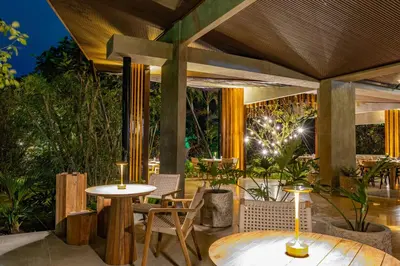 an outdoor patio with a table and chairs and lights at Noah's Forest by Tifakara in Fortuna