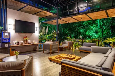 a living room with couches and a tv and trees at Noah's Forest by Tifakara in Fortuna