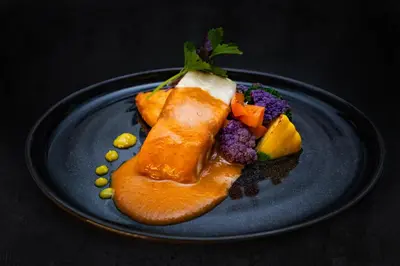 a blue plate with a piece of fish and vegetables at Noah's Forest by Tifakara in Fortuna