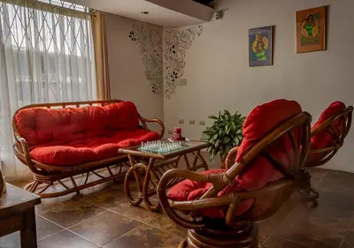 a living room with a red couch and chairs at Eco Stay Hostel in San José