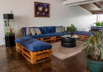 a living room with a blue couch and a table at Eco Stay Hostel in San José