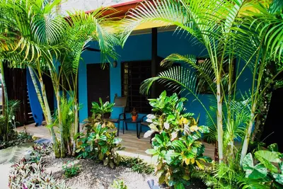 a house with palm trees and a wooden deck at Cabinas D’Val in Uvita