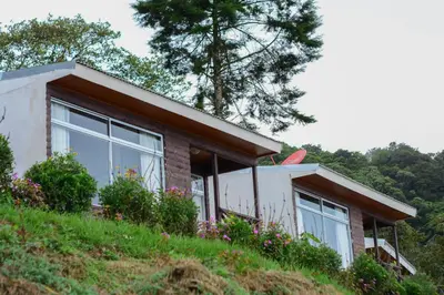 a house on top of a hill with flowers at Hotel Vistas del Cielo in Cartago