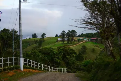 a road on a hill with a white fence at Hotel Vistas del Cielo in Cartago